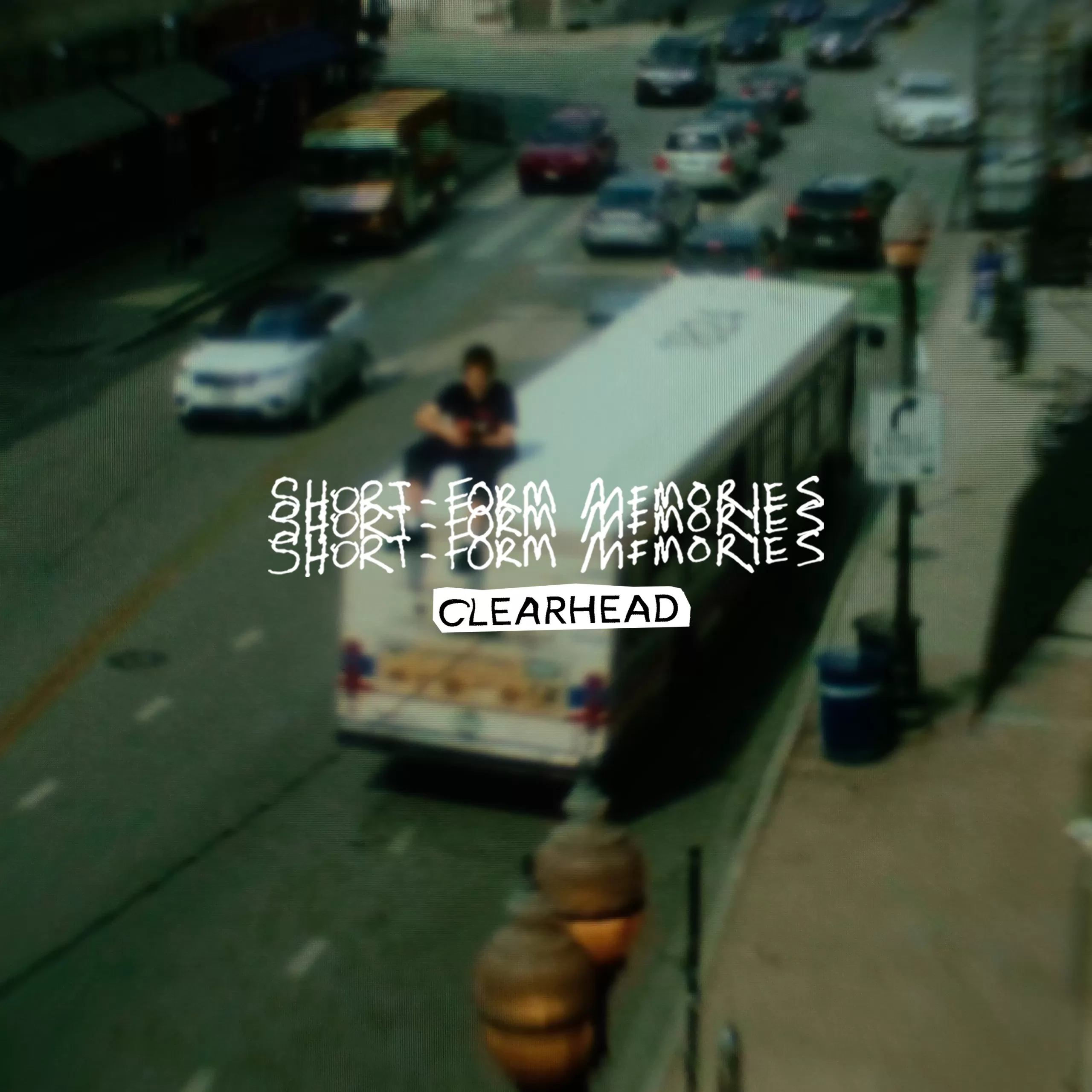 Text in white reading "SHORT-FORM MEMORIES" CLEARHEAD is on top of a photo of a buzy street with a guy playing guitar on top of a bus.